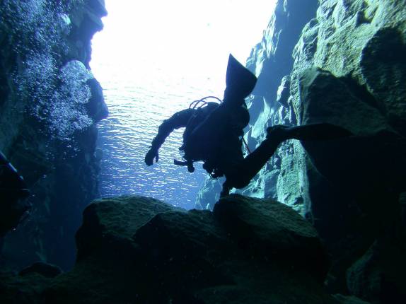 Mergulhando entre a América e a Europa na Silfur Hellir, a fenda que divide esses continentes, no Parque Nacional Thingvellir, na Islândia